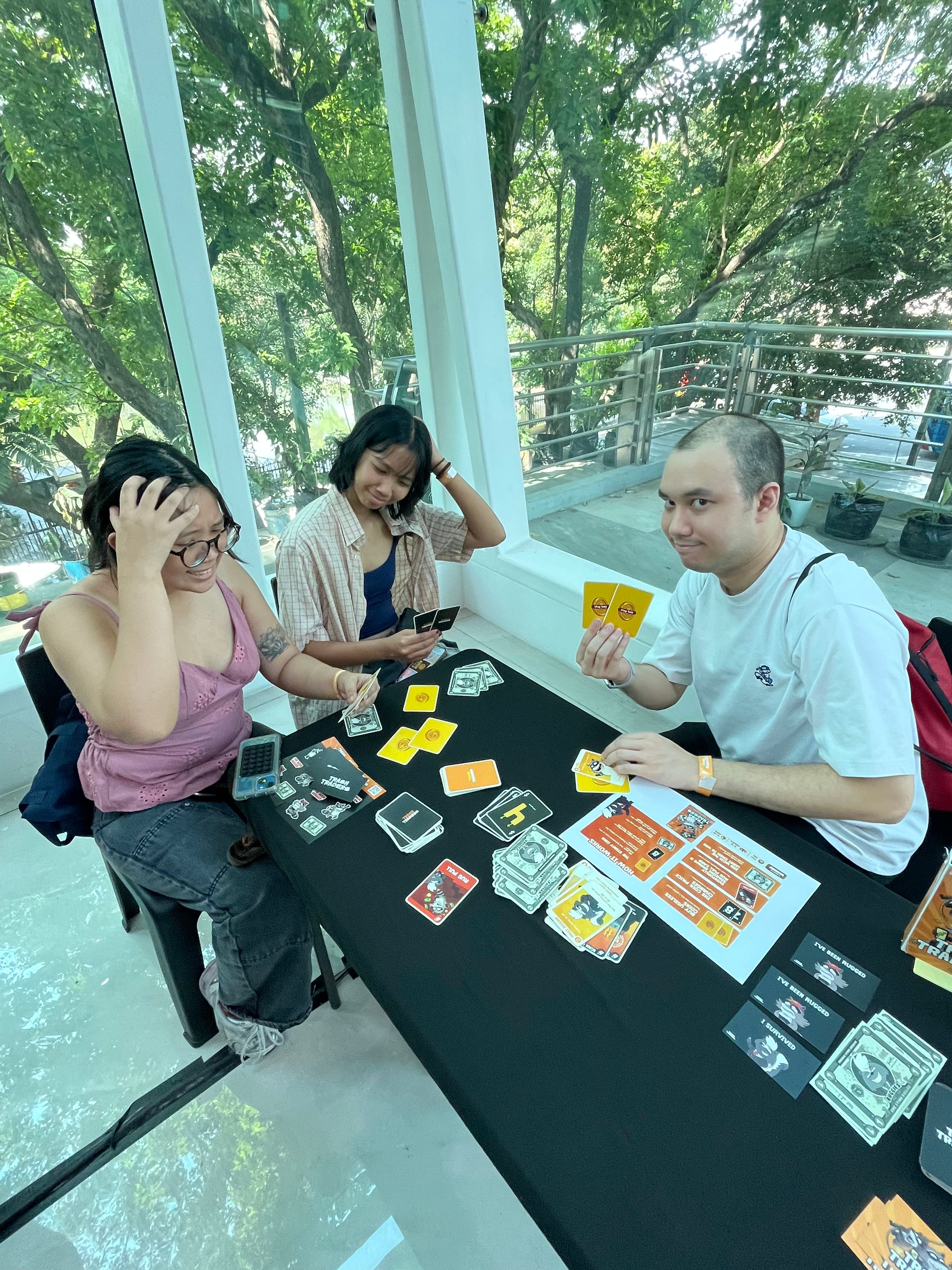 Friends reacting during a Trash Traders game night