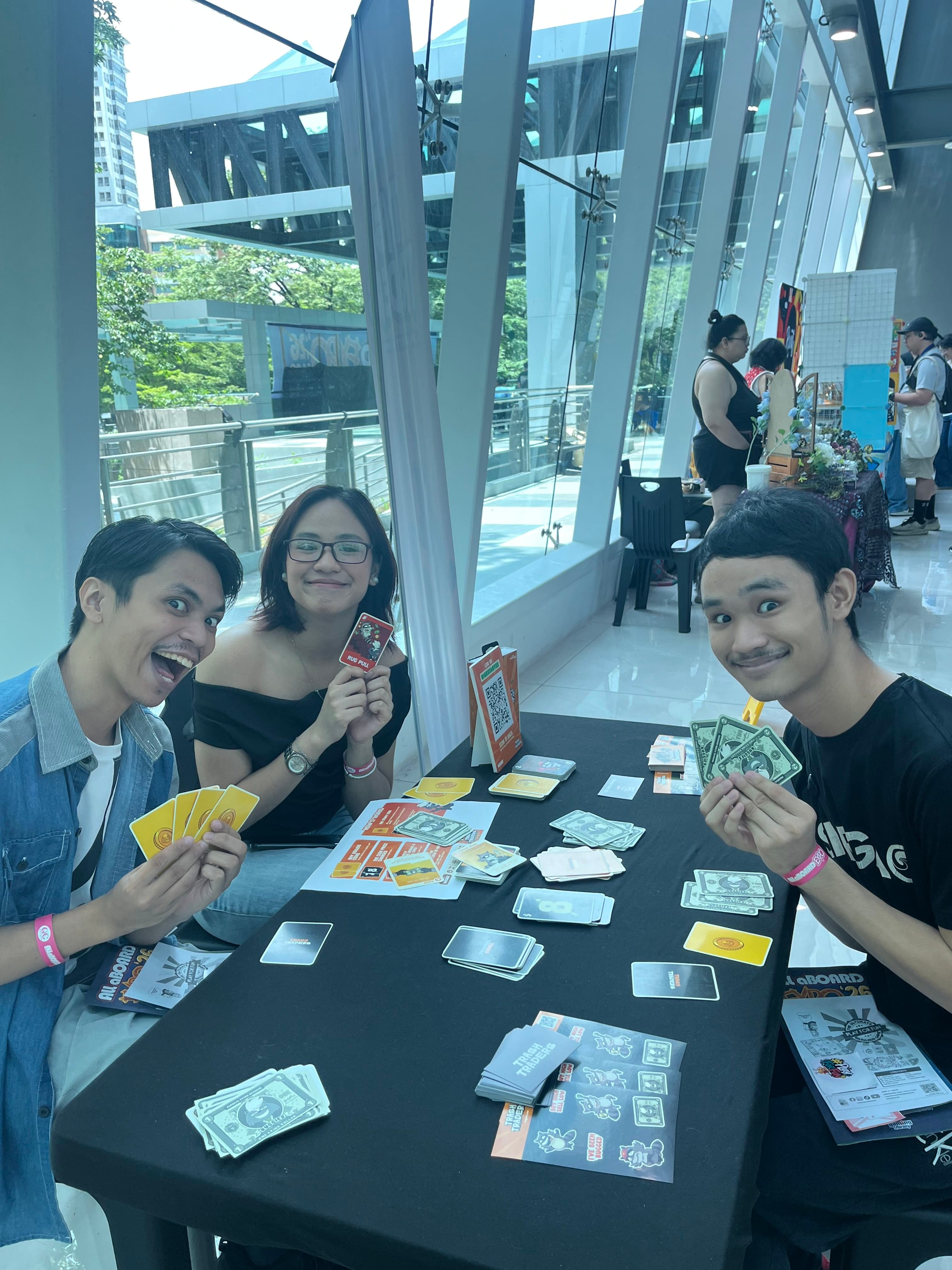 Friends playing Trash Traders at a booth